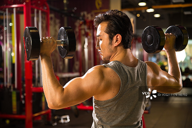 青年男人在健身房里健身图片素材