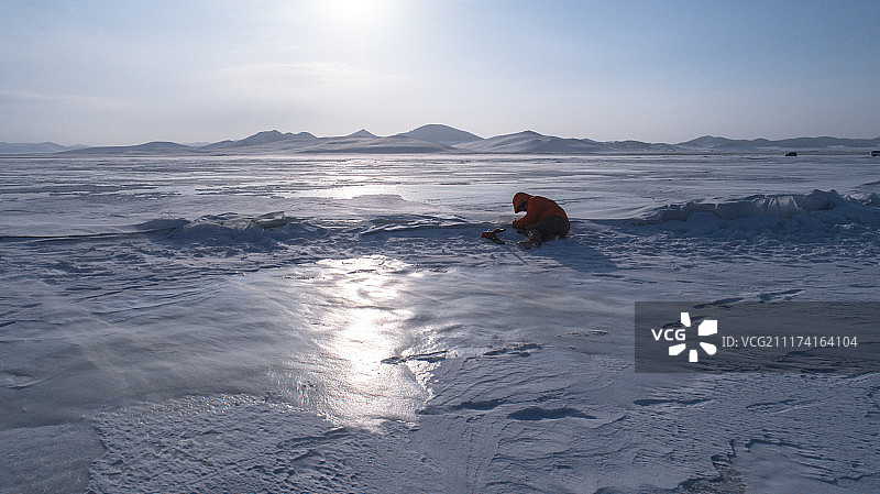 航拍摄影工作者在雪地上拍摄图片素材