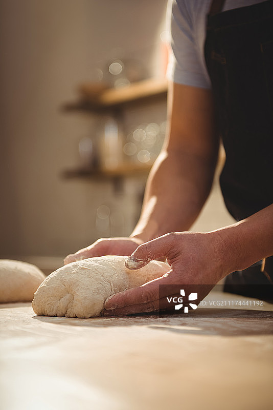 厨师在专业厨房揉面图片素材