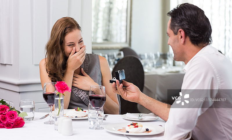 在餐厅里，男人向惊讶的女人求婚图片素材