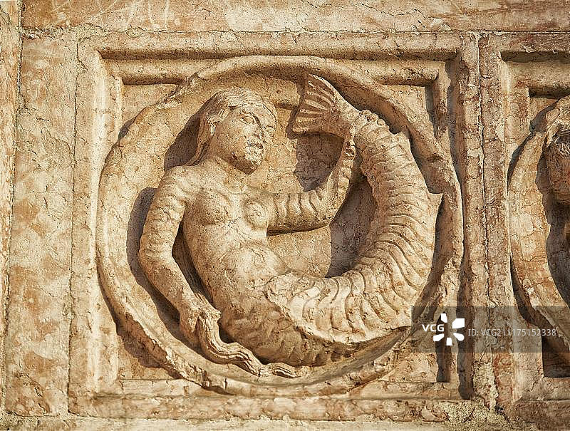 罗马涅风格的帕尔马洗礼堂外墙上神话美人鱼的中世纪浮雕雕塑，意大利艾米利亚罗马涅图片素材