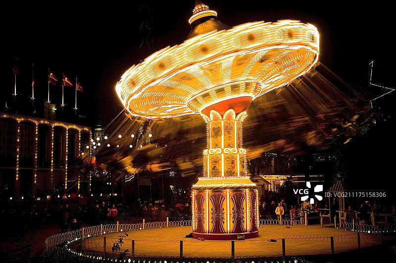 夜间旋转木马：丹麦哥本哈根蒂沃利公园图片素材
