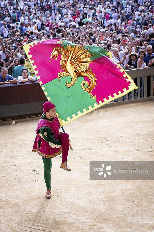 锡耶纳赛马节历史游行中的男子，手持古代旗帜图片素材