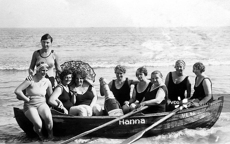 度假：九名身穿泳衣的女子在海滩的划艇上拿着大香槟酒瓶合影，1920年代，波罗的海，吕根岛，德国，欧洲图片素材