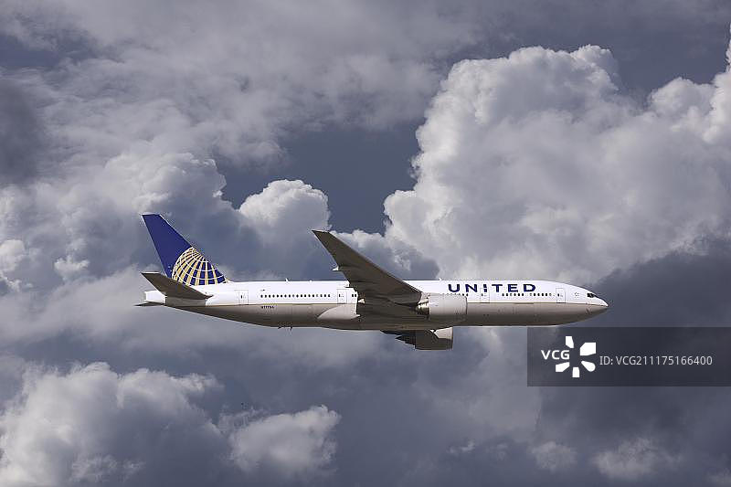 恶劣天气中飞行的美国联合航空公司波音777飞机图片素材
