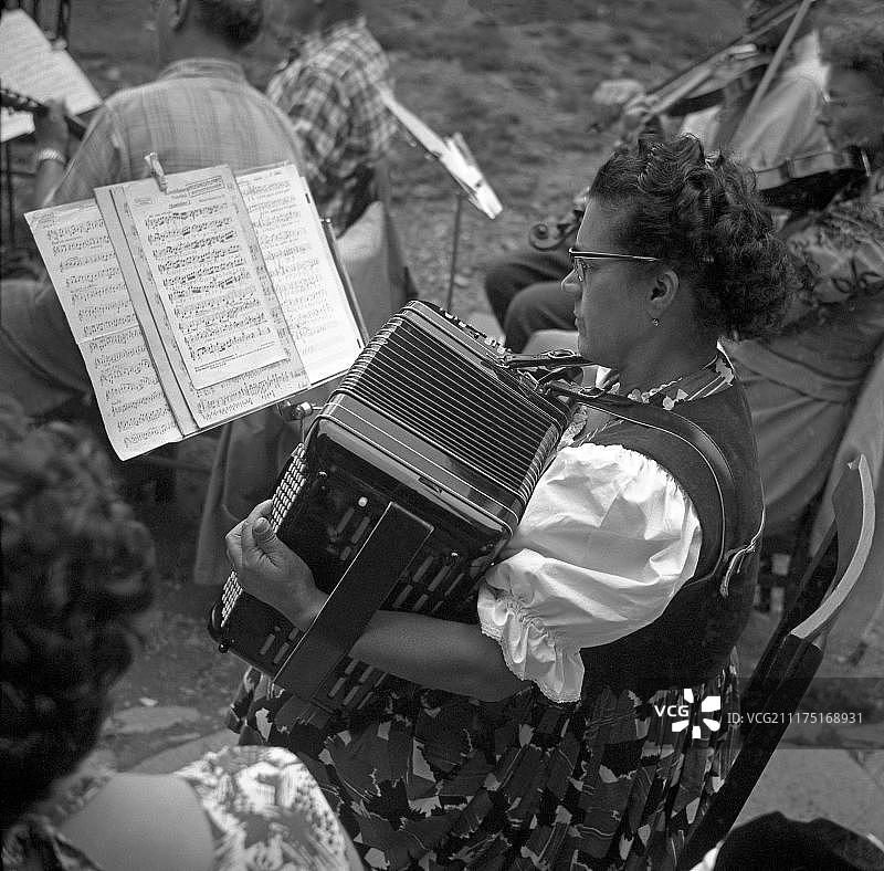 女人在音符后演奏手风琴，手风琴演奏者，约1955年，德国弗莱堡图片素材