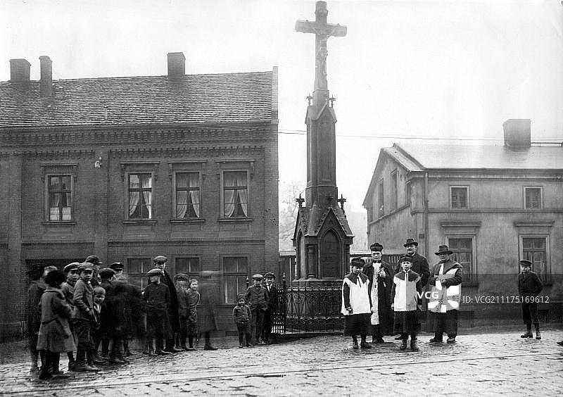 约1930年的村庄广场上有神父和祭童，确切地点不详，德国，欧洲图片素材
