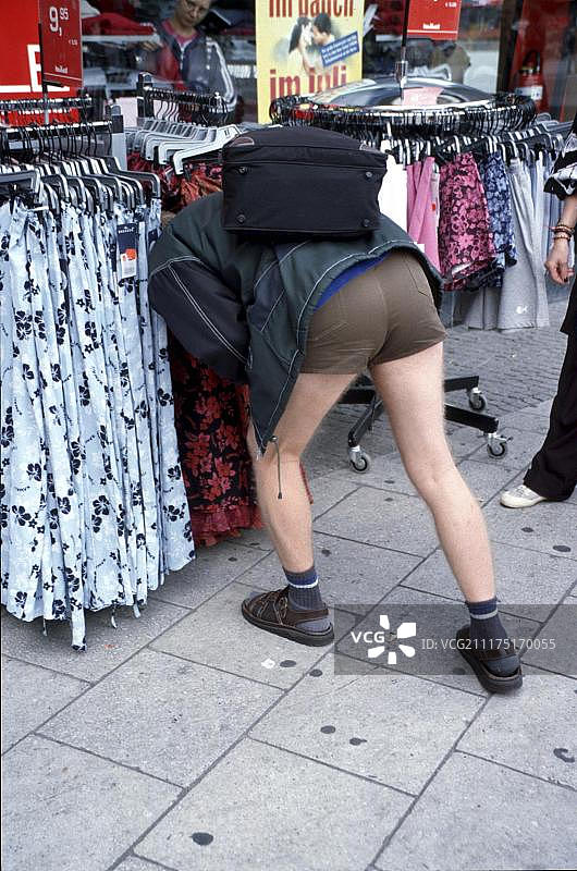 在德国柏林，男人将头伸入衣架之间图片素材