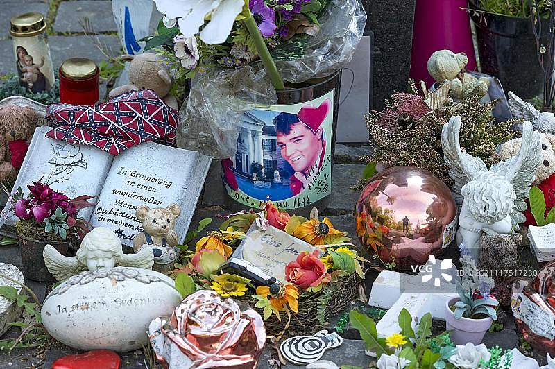 位于德国黑森州巴特瑙海姆格鲁内瓦尔德酒店猫王故居前，纪念他的石碑旁的粉丝礼物图片素材