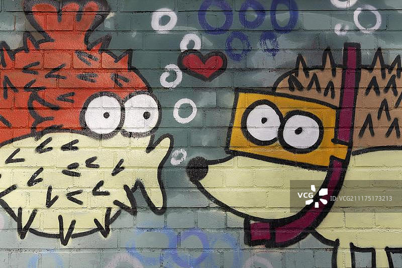 亲吻戴护目镜刺猬的多刺鱼形雕塑，壁画，德国北莱茵-威斯特法伦图片素材