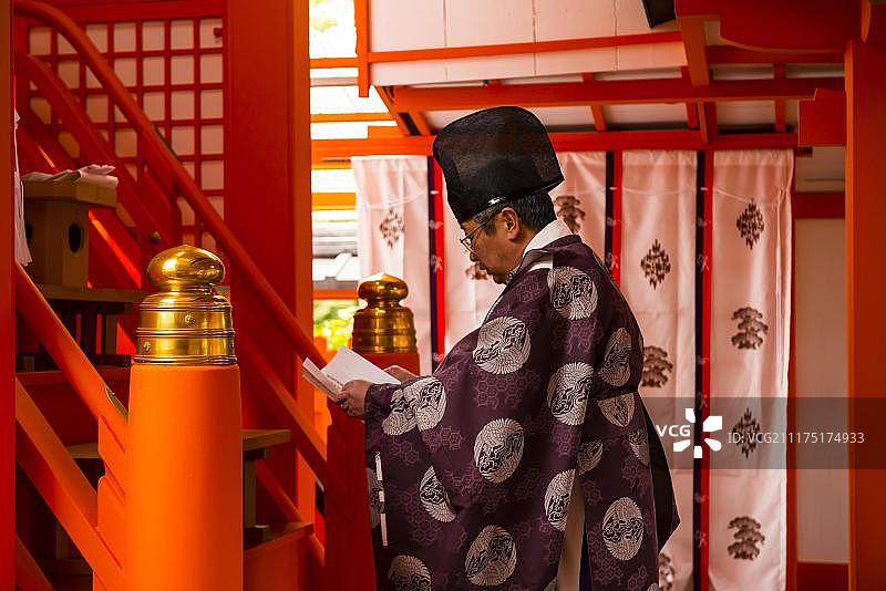 男人在日本京都伏见稻荷大社祈祷图片素材