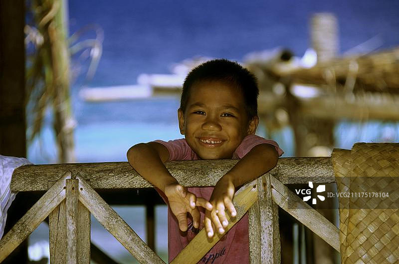 站在菲律宾巴里卡萨岛栏杆上的菲律宾男孩图片素材