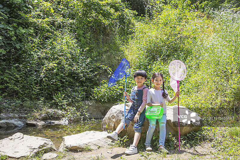 可爱的小男孩和女孩一起收获，园艺种植概念照片图片素材