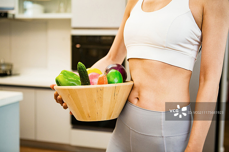 穿着运动装的青年女人在厨房图片素材