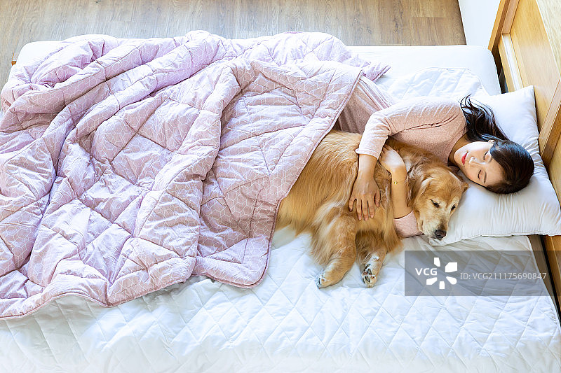 宠物与单身女子在卧室里休息图片素材