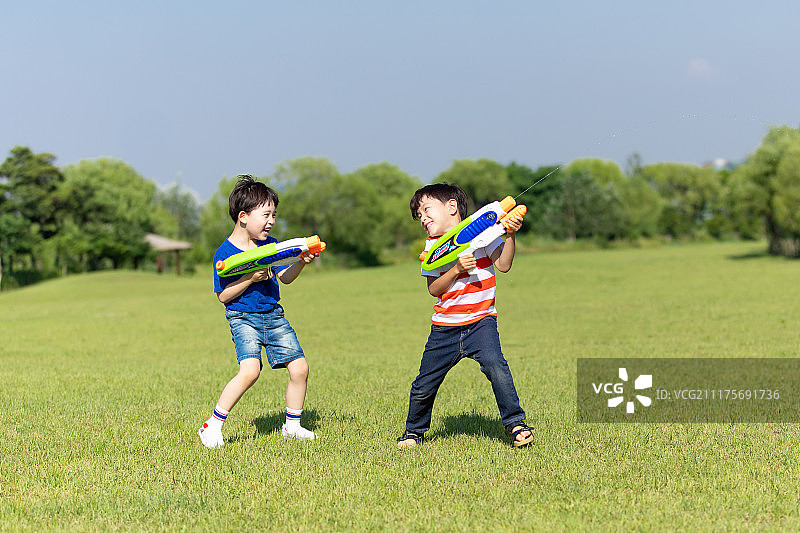 孩子们的夏日田野嬉戏：水枪大战图片素材