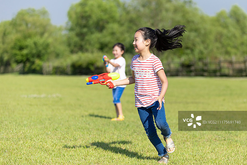 孩子们的夏日田野嬉戏：水枪大战图片素材