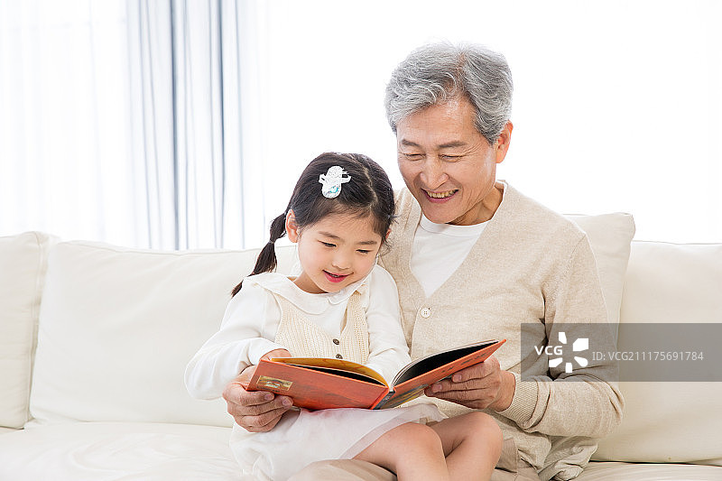 幼儿园里，祖父母给孙女讲故事图片素材
