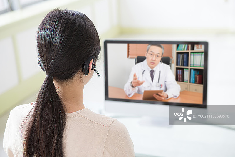 坐在沙发上的女人，远程医疗，电话会议，医生与病人交谈图片素材