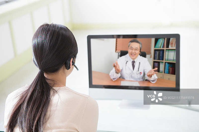 坐在沙发上的女人，远程医疗，电话会议，医生与病人交谈图片素材