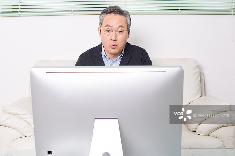 韩国中年男人，沙发，坐姿，电脑显示器图片素材