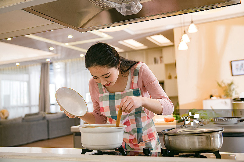 青年女人在厨房煲汤图片素材