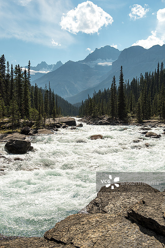 岩石河流与河岸树木、后方山脉景观图片素材