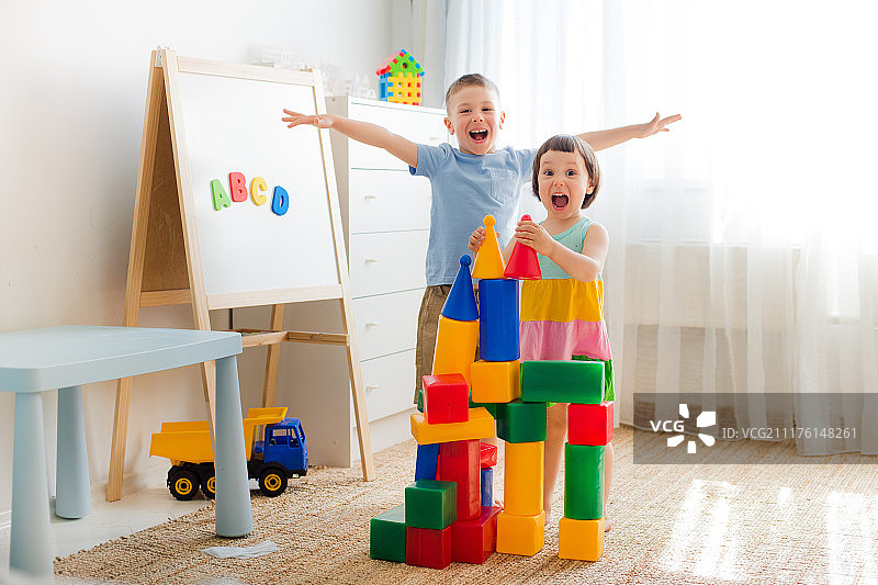 快乐的学龄前儿童玩玩具积木图片素材