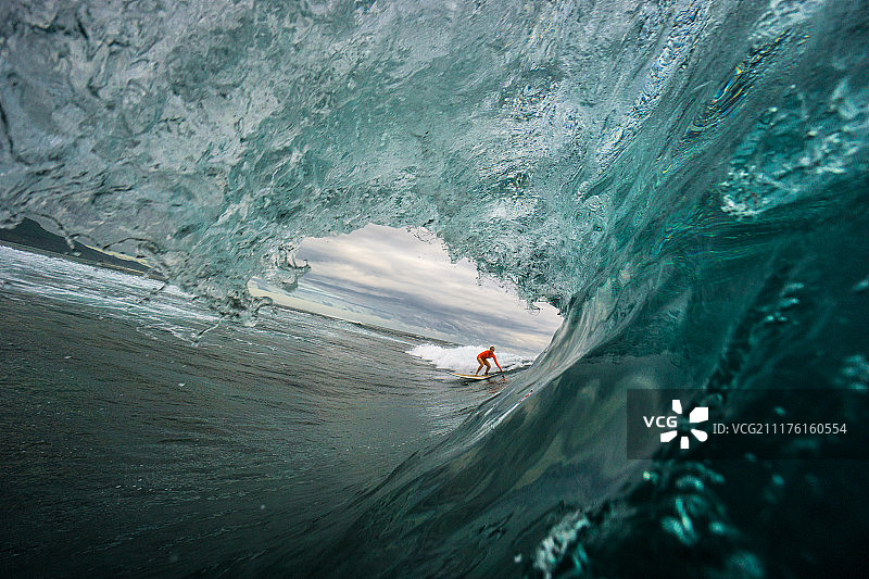 在毛里求斯岛的开阔海域大浪上冲浪的年轻漂亮金发女孩图片素材