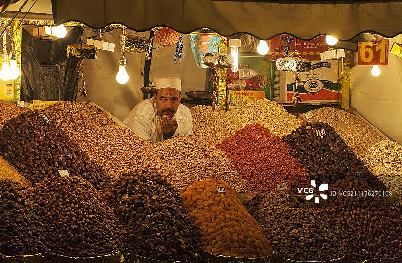 男人在非洲摩洛哥马拉喀什Jemaa el-Fnaa广场的市场摊位上出售干果和坚果图片素材