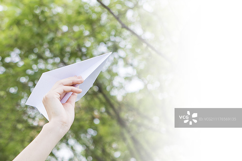 拿着纸飞机的年轻女人图片素材