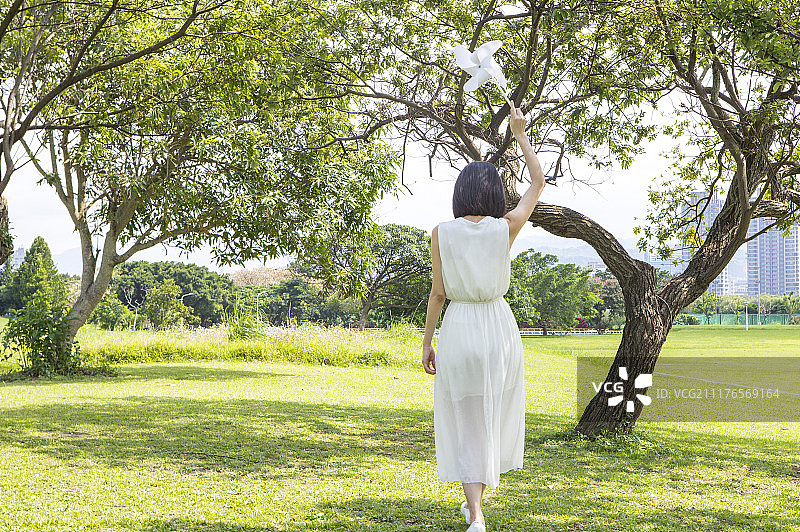 高举风车的年轻女人图片素材