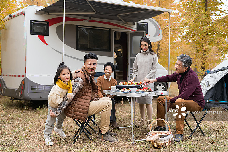 快乐的一家五口秋游户外烧烤图片素材