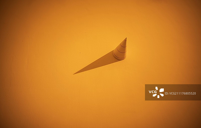 橘黄色灯光下墙上的圆锥体图片素材