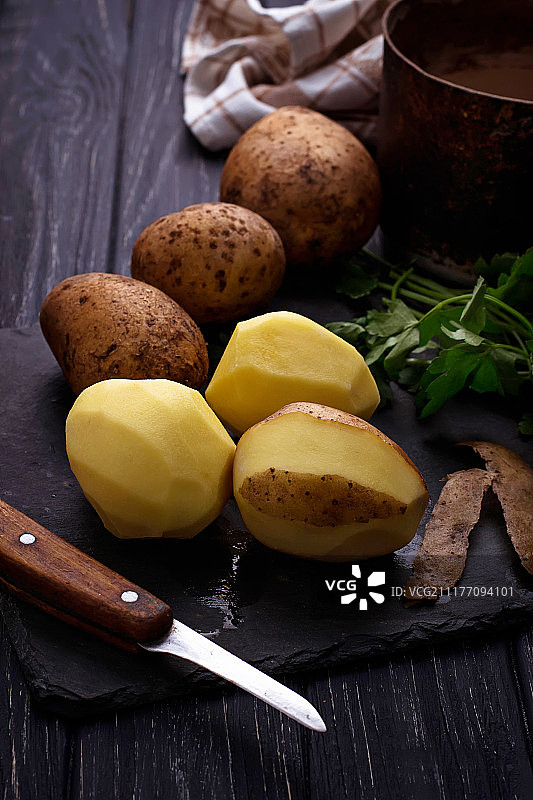 深色背景上的未煮去皮土豆图片素材