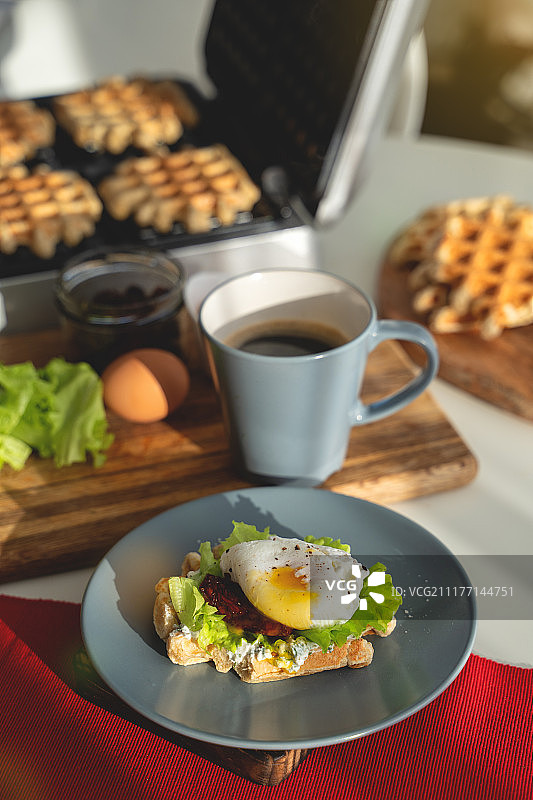 搭配面包和番茄的班尼迪克蛋，配有培根早餐三明治图片素材