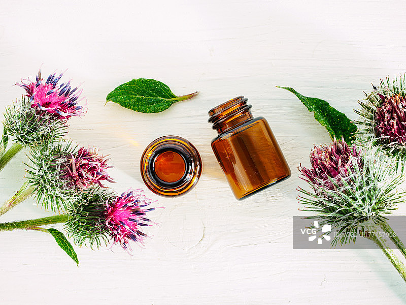 小玻璃瓶中的牛蒡油，俯视，留白图片素材