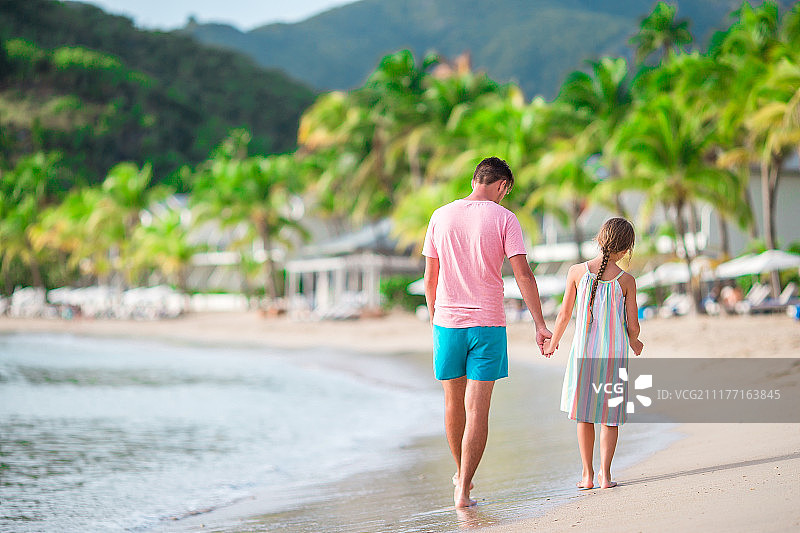 一家人在热带卡莱尔海湾沙滩上散步图片素材
