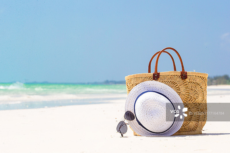 沙滩上的海滩配件 - 草编包、帽子和太阳镜图片素材