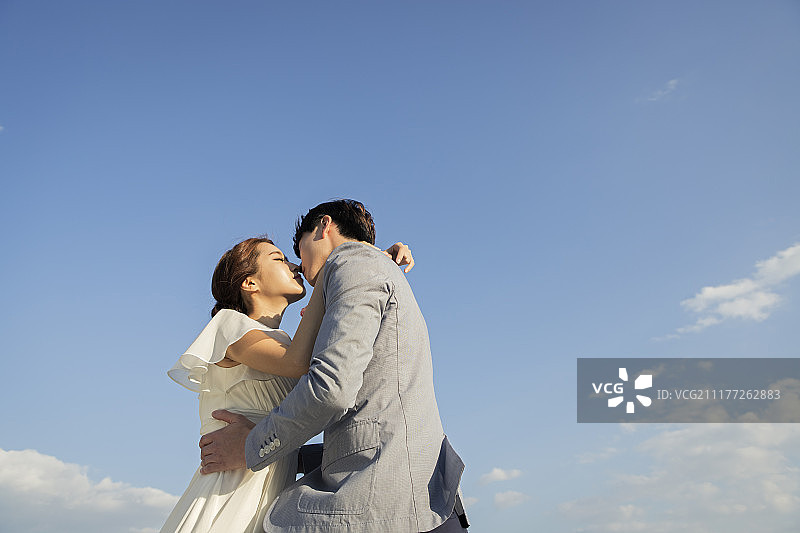 在济州岛户外接吻的新婚夫妇摄影图片素材