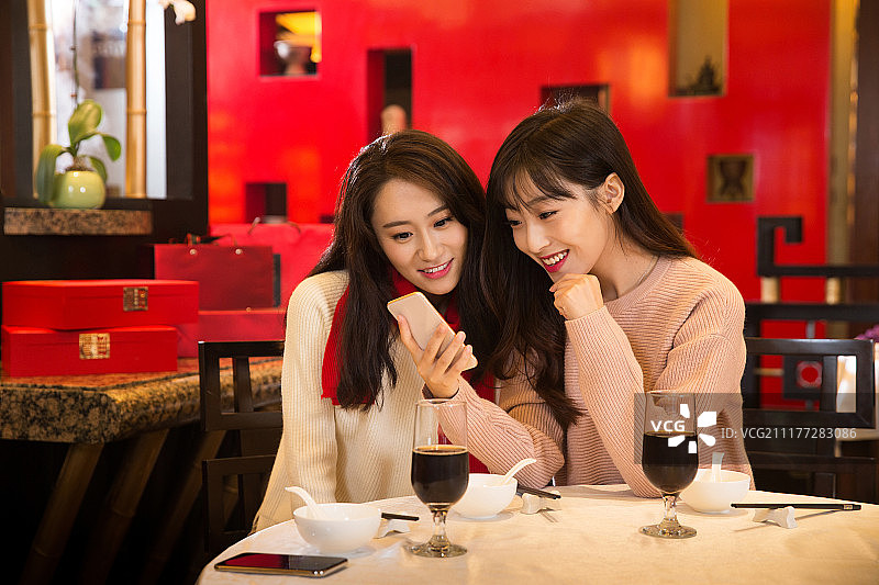 青年闺蜜看手机图片素材