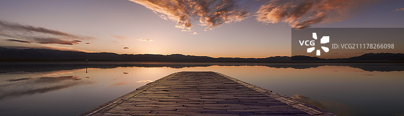 青海日落时分的静谧湖面和堤岸图片素材