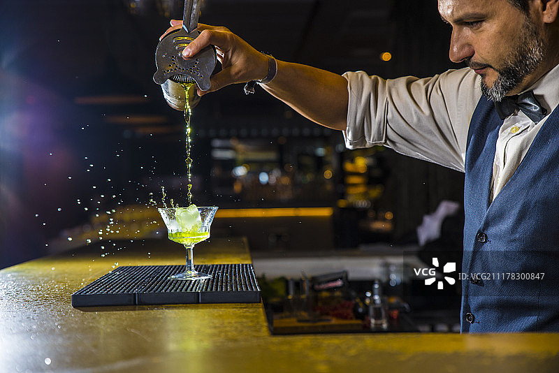 酒吧招待在夜总会调制鸡尾酒图片素材
