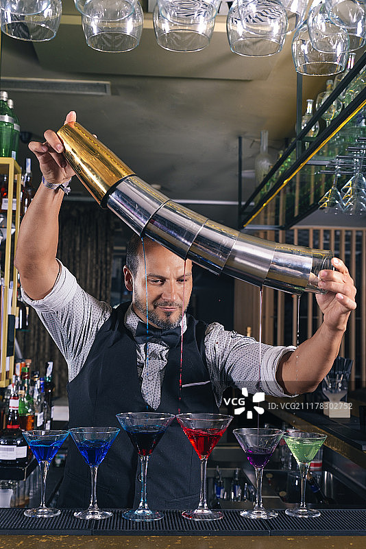 酒吧招待在夜总会调制鸡尾酒图片素材