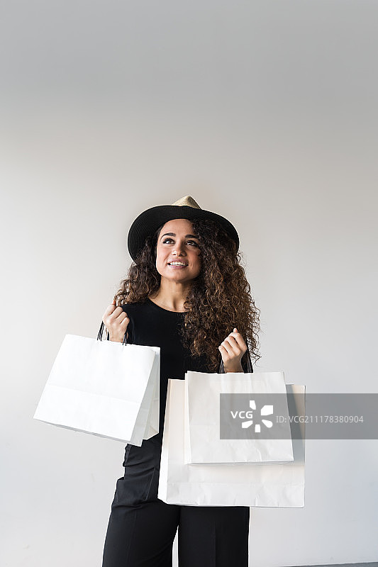 手提白色购物袋的快乐美丽女人图片素材