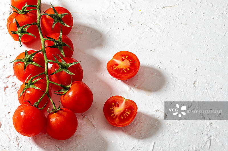 枝条上的美丽樱桃番茄，白色纹理背景图片素材