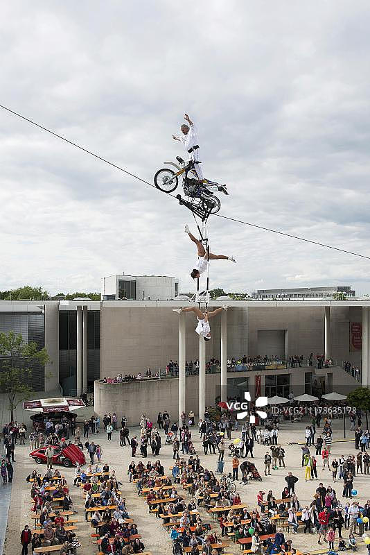 博物馆英里节：走钢丝艺术家法尔科·特拉贝尔在细绳上骑摩托车，观众在下方，德国北莱茵-威斯特法伦州波恩图片素材