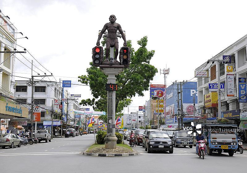 泰国甲米镇：手持交通灯的穴居人雕塑图片素材
