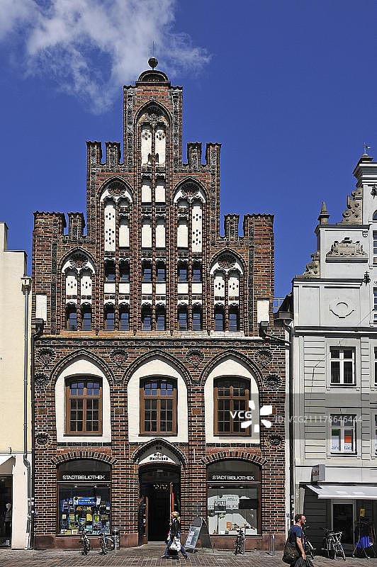 带有乌鸦阶梯式山墙的红砖哥特式建筑，德国罗斯托克公共图书馆图片素材