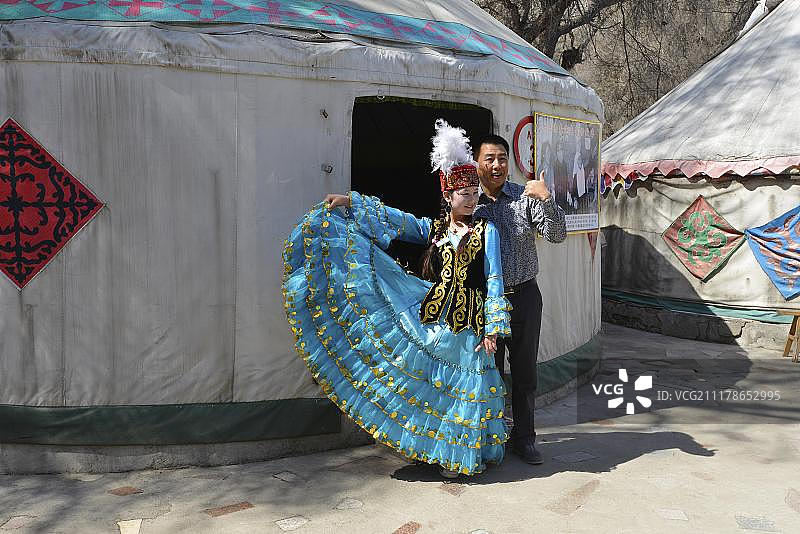 新疆维吾尔自治区少数民族旅游：游客在天山天池前与哈萨克族舞蹈演员合影图片素材